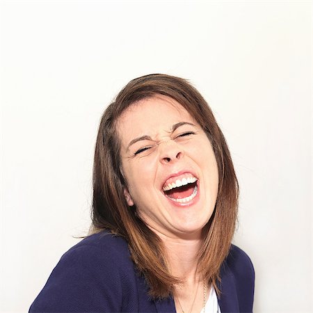 false - Young woman laughing against white background Stock Photo - Premium Royalty-Free, Code: 649-06829719
