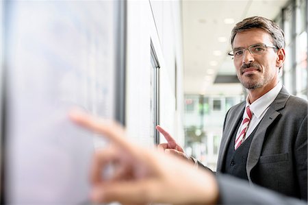 Businessmen interacting with touch screens Stock Photo - Premium Royalty-Free, Code: 649-06829817