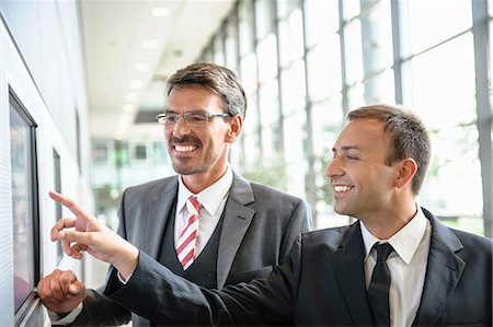 project - Businessmen pointing and looking at wall screen Stock Photo - Premium Royalty-Free, Code: 649-06829818