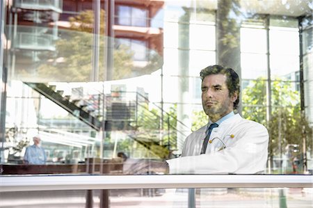 simsearch:649-06829838,k - Portrait of male doctor looking out of window Fotografie stock - Premium Royalty-Free, Codice: 649-06829837