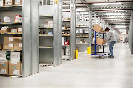 simsearch:632-03500555,k - Female warehouse worker collecting orders on delivery trolley Fotografie stock - Premium Royalty-Free, Codice: 649-06829916