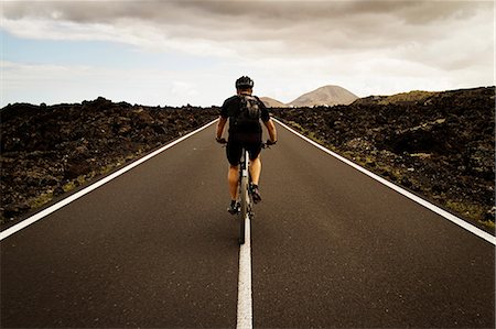 simsearch:649-06829976,k - Man mountain biking on road, Lanzarote Fotografie stock - Premium Royalty-Free, Codice: 649-06829974