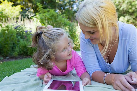 family fun outdoors summer grass - Mother and daughter lying on blanket in garden using digital tablet Stock Photo - Premium Royalty-Free, Code: 649-06830032