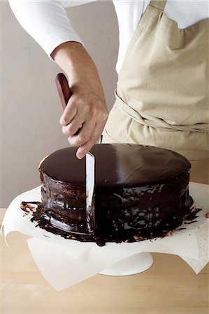 simsearch:649-06830081,k - Woman spreading melted chocolate on cake Foto de stock - Sin royalties Premium, Código: 649-06830088