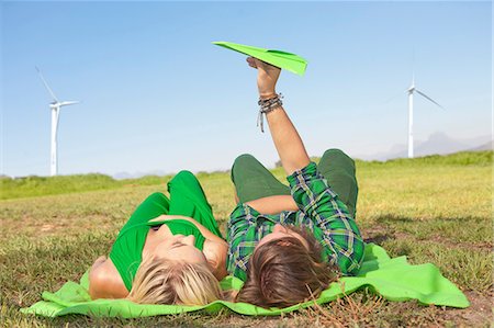 pictures of windmills in south africa - Young couple lying in field, man holding paper aeroplane Stock Photo - Premium Royalty-Free, Code: 649-06830094