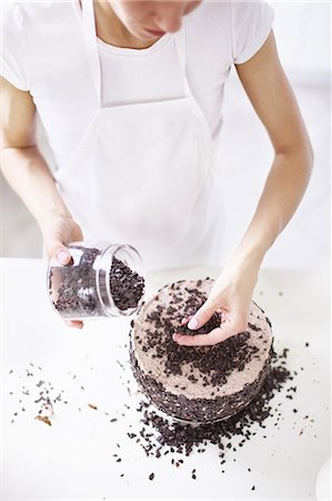 simsearch:649-06830170,k - Woman sprinkling chocolate chips on cake Stock Photo - Premium Royalty-Free, Code: 649-06830169