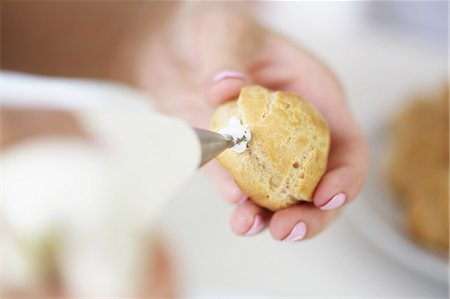 pâtissier (homme et femme) - Woman filling profiterole with cream Photographie de stock - Premium Libres de Droits, Code: 649-06830174