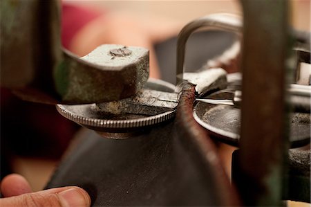 Close up of person using machine to work leather Photographie de stock - Premium Libres de Droits, Code: 649-06844099
