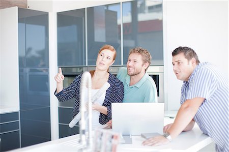 Young couple with salesman in kitchen showroom Foto de stock - Sin royalties Premium, Código: 649-06844114