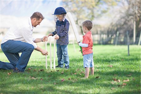 father teaching his child - Father and sons preparing stumps for cricket Stock Photo - Premium Royalty-Free, Code: 649-06844115