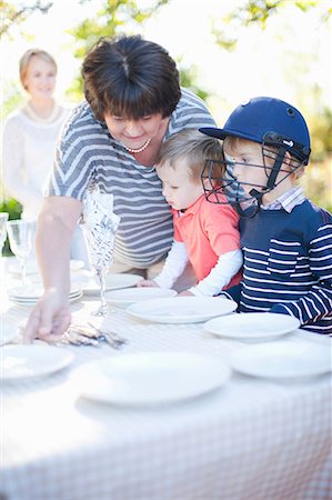 seniors barbecuing - Boys and grandmother setting dinner table outdoors Stock Photo - Premium Royalty-Free, Code: 649-06844124