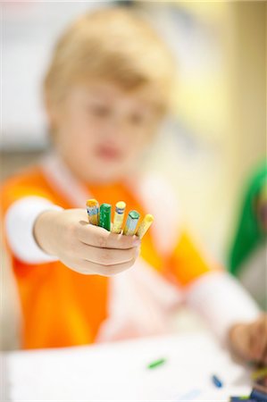 Boy holding out crayons Photographie de stock - Premium Libres de Droits, Code: 649-06844155