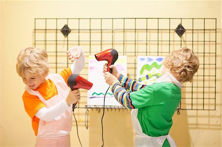 simsearch:632-02690128,k - Boys playing with hair dryers whilst drying their paintings Stock Photo - Premium Royalty-Free, Code: 649-06844162