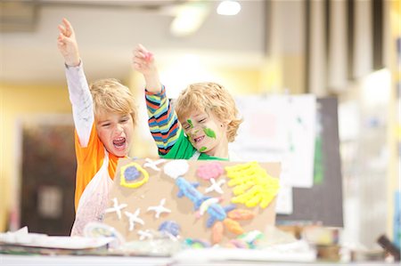 Boys showing their artistic creation with arms raised Photographie de stock - Premium Libres de Droits, Code: 649-06844177