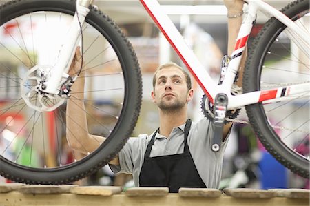 Young man holding bicycle in repair shop Foto de stock - Sin royalties Premium, Código: 649-06844219