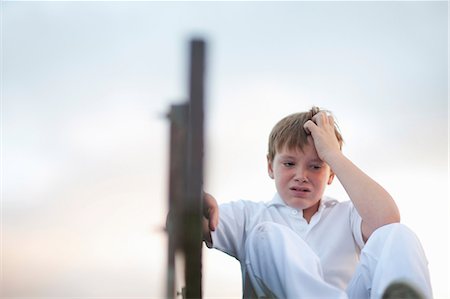 Boy on bleachers at cricket pitch scratching head Foto de stock - Sin royalties Premium, Código: 649-06844275