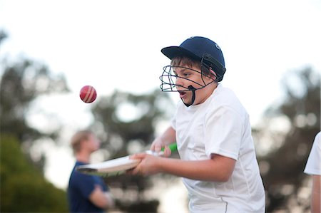 simsearch:649-06844269,k - Boy practising hitting cricket ball with bat Fotografie stock - Premium Royalty-Free, Codice: 649-06844277