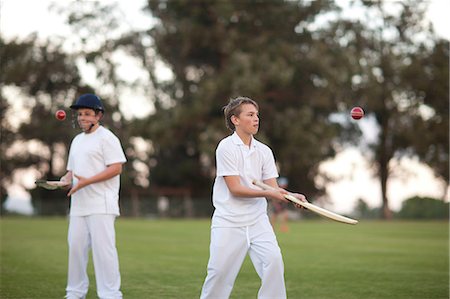 simsearch:649-06844269,k - Boys practising hitting cricket ball with bat Fotografie stock - Premium Royalty-Free, Codice: 649-06844278