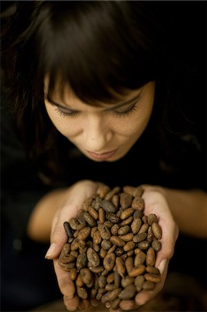 simsearch:649-06844312,k - Woman holding handful of cocoa beans Foto de stock - Royalty Free Premium, Número: 649-06844311