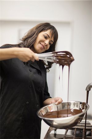 simsearch:649-06844312,k - Woman with mixing bowl and melted chocolate Foto de stock - Royalty Free Premium, Número: 649-06844321