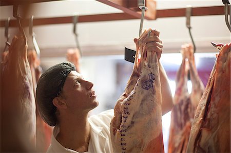 Butcher inspecting meat Fotografie stock - Premium Royalty-Free, Codice: 649-06844337