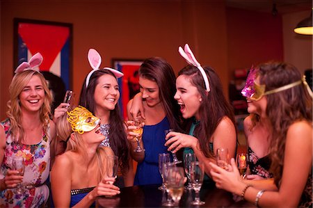 simsearch:649-06844392,k - Young women laughing with drinks at hen party Stock Photo - Premium Royalty-Free, Code: 649-06844384