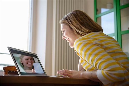 Young woman on video call with friend Stock Photo - Premium Royalty-Free, Code: 649-06844429