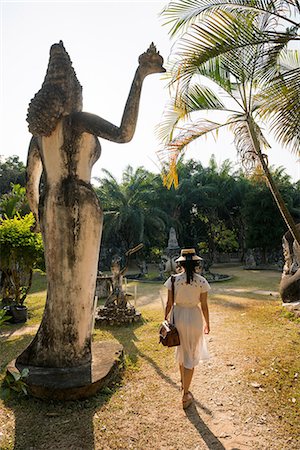 Woman walking past statue, Xieng Khu, Vientiane, Laos Fotografie stock - Premium Royalty-Free, Codice: 649-06844454