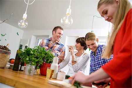 simsearch:649-06844439,k - Mother with grown up children preparing food in kitchen Photographie de stock - Premium Libres de Droits, Code: 649-06844450