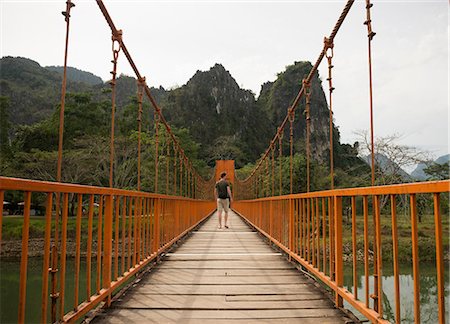 simsearch:649-06844461,k - Man on bridge over river, Vang Vieng, Laos Fotografie stock - Premium Royalty-Free, Codice: 649-06844466