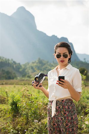 sunglasses field - Woman using smartphone, Vang Vieng, Laos Stock Photo - Premium Royalty-Free, Code: 649-06844479