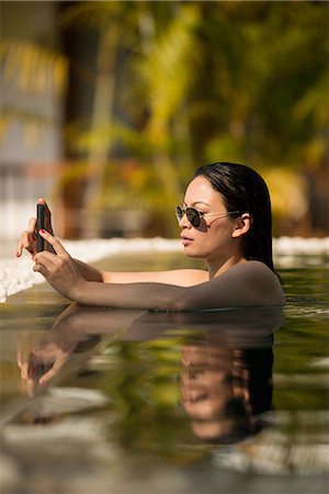 simsearch:649-06844461,k - Woman using smartphone in  swimming pool Fotografie stock - Premium Royalty-Free, Codice: 649-06844485