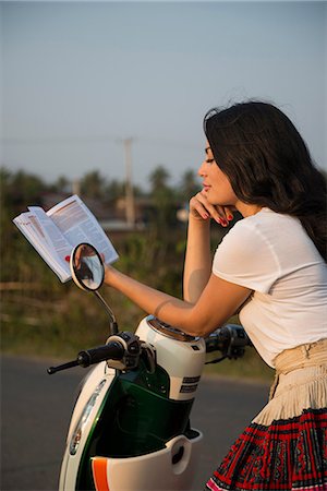 Woman leaning on moped reading book Foto de stock - Sin royalties Premium, Código: 649-06844506