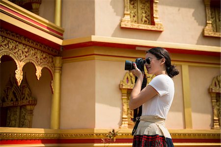 Woman taking photograph outside building, Luang Prabang, Laos Foto de stock - Sin royalties Premium, Código: 649-06844501