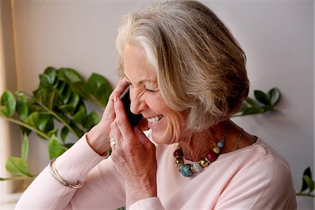 Senior woman using mobile phone, smiling Stock Photo - Premium Royalty-Free, Code: 649-06844555