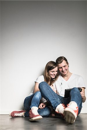 Teenage couple watching digital tablet, sharing earphones Stock Photo - Premium Royalty-Free, Code: 649-06844572