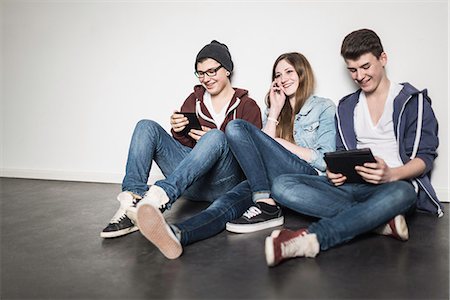 simsearch:649-06844592,k - Three teenagers sitting on floor using technology Photographie de stock - Premium Libres de Droits, Code: 649-06844581