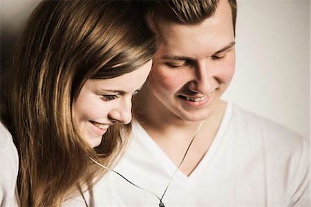 Teenage couple smiling and sharing earphones Foto de stock - Sin royalties Premium, Código: 649-06844601