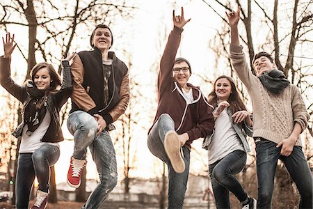 Five teenagers fooling around, jumping in park Stock Photo - Premium Royalty-Free, Code: 649-06844610