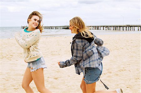 running blonde woman - Girlfriends playing chasing game on the beach Stock Photo - Premium Royalty-Free, Code: 649-06844674