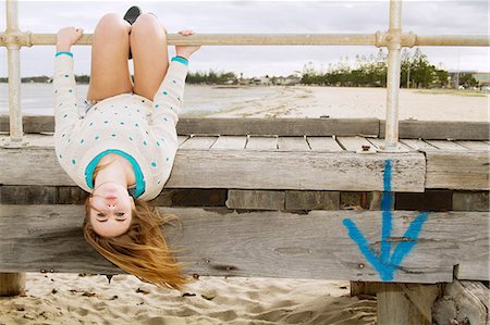 dangling - Young woman hanging upside down from pier Stock Photo - Premium Royalty-Free, Code: 649-06844680