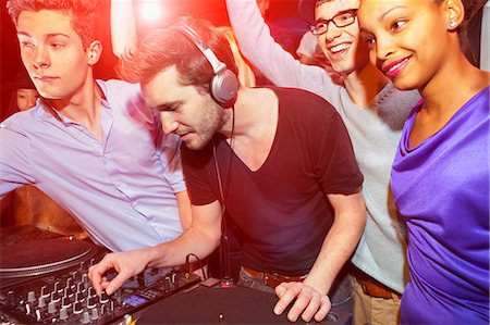 people at party or club - Disc jockey with group of people behind mixing desk Stock Photo - Premium Royalty-Free, Code: 649-06844706