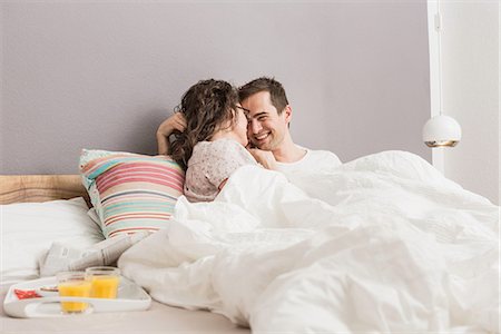 Mid adult couple lying in bed, breakfast on tray Stock Photo - Premium Royalty-Free, Code: 649-06844774