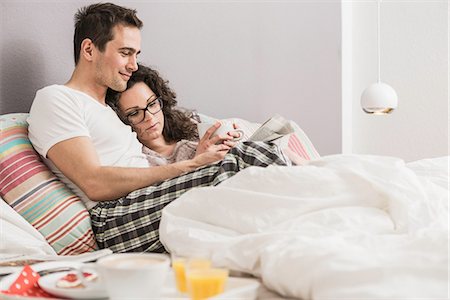 eyeglasses and newspaper - Mid adult couple reading newspaper in bed Stock Photo - Premium Royalty-Free, Code: 649-06844779