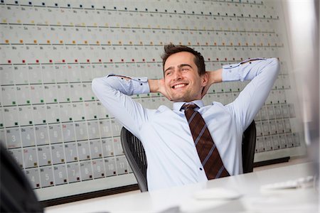 Businessman leaning back in chair with arms behind head Stock Photo - Premium Royalty-Free, Code: 649-06844805