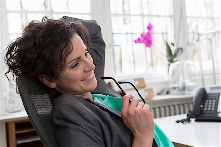 people reclining images - Businesswoman leaning back in office chair, hand in hair Stock Photo - Premium Royalty-Free, Code: 649-06844818
