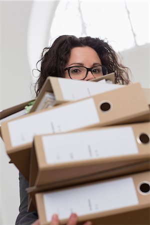 paper work stacked - Businesswoman obscured by pile of folders Stock Photo - Premium Royalty-Free, Code: 649-06844820