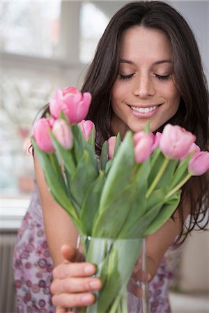 Mid adult woman holding vase of pink flowers Stock Photo - Premium Royalty-Free, Code: 649-06844849
