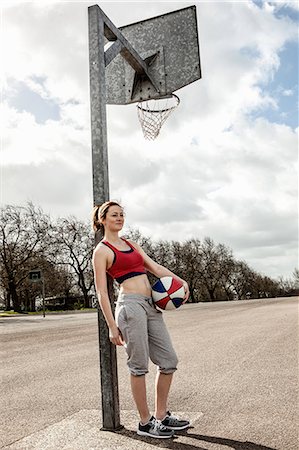 Woman with ball leaning against netball goalpost Photographie de stock - Premium Libres de Droits, Code: 649-06844928