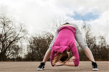 skinny sports woman - Woman doing bending forward exercise Stock Photo - Premium Royalty-Free, Code: 649-06844936
